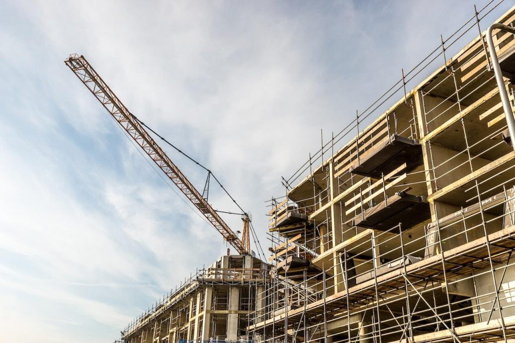 Werker op een soort steiger tijdens bouwwerk, veilige werkomgeving op hoogte